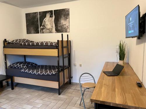 Zimmer mit Etagenbetten und einem Schreibtisch mit einem Laptop in der Unterkunft Möblierte 1-Zimmer Wohnung im Zentrum Ottersbergs für Monteure und geschäftlich Reisende in Ottersberg