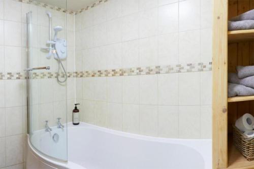a bathroom with a tub and a shower at The Barn - Yorkshire Coast Holiday Lets in Whitby