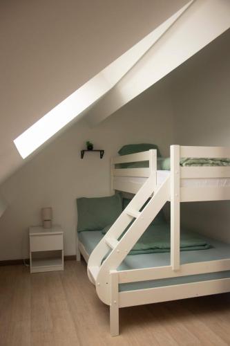 a bedroom with two bunk beds in a attic at Cosy 2-Bedroom Apartment in the center of Hotton in Hotton