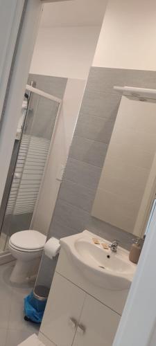 a bathroom with a sink and a toilet and a mirror at InBlu in Bari