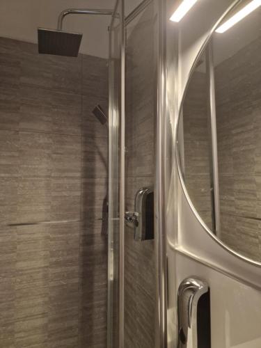 una ducha con puerta de cristal en un baño en Hostal Esparteros, en Madrid