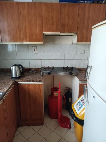 eine Küche mit einem roten Staubsauger in der Ecke einer Küche in der Unterkunft OMAR Vacation in Dubai