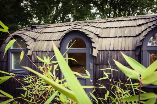 a small wooden cabin with a tin roof at Tiny House Kotten Kunterbunt in Nottuln