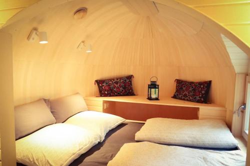 een kamer met 2 bedden in een ronde kamer bij Tiny House Kotten Kunterbunt in Nottuln