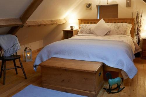 a bedroom with a large bed and a wooden table at The Barn - Yorkshire Coast Holiday Lets in Whitby