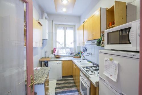 a kitchen with white appliances and a stove top oven at Living in San Peter in Rome