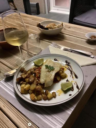 a plate of food on a table with a glass of wine at L'instant d'un séjour in Le Guâ
