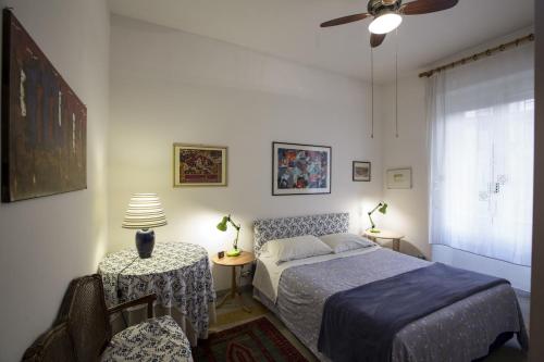 1 dormitorio con 1 cama y 1 mesa con lámpara en Living in San Peter, en Roma