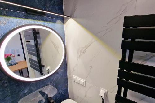 a bathroom with a round mirror and a sink at Gwiazda Kaszub in Chmielno