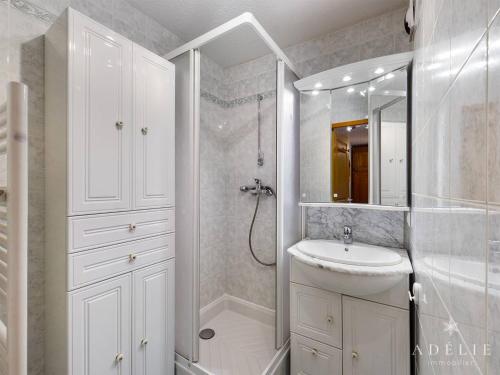 La salle de bains blanche est pourvue d'un lavabo et d'une douche. dans l'établissement Appartement Montvalezan-La Rosière, 2 pièces, 4 personnes - FR-1-398-617, à Montvalezan