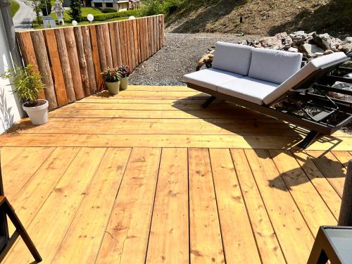 a chair sitting on a wooden deck at Haus Tilia Karinthië Appartementen in Nötsch