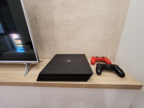 a laptop and a video game controller on a shelf at Apartman Lux Titova Vila Plus Sony PS in Zlatibor