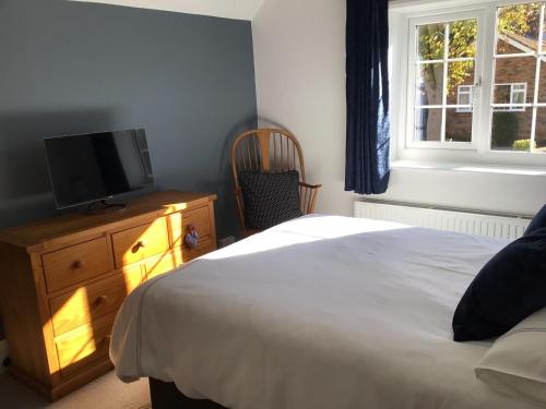 a bedroom with a bed and a television on a dresser at Icthus in Willerby