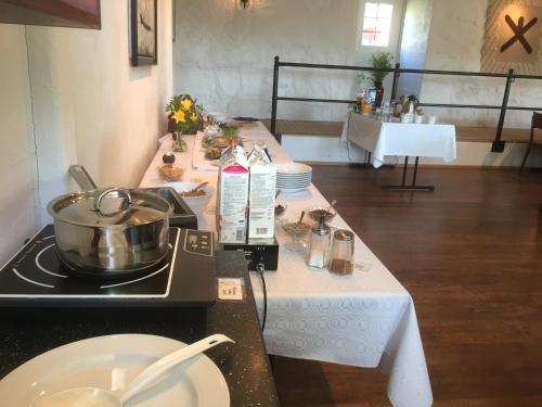 a kitchen with a table with a pot on a stove at Hotel Stallbacken Nagu in Nauvo