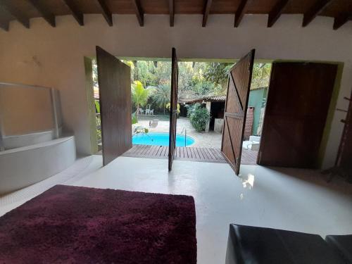 a room with doors open to a swimming pool at Casa Solar in Rio de Janeiro