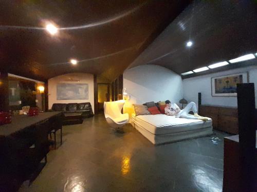 a person laying on a couch in a living room at Casa Solar in Rio de Janeiro