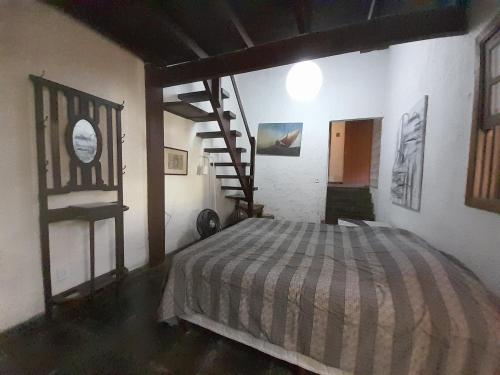 a bedroom with a bed and a spiral staircase at Casa Solar in Rio de Janeiro