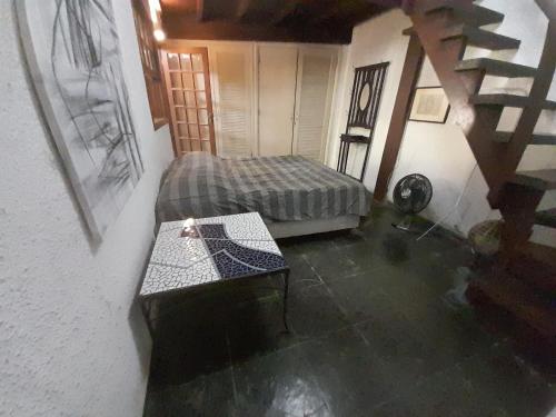 a room with a bed and a table and stairs at Casa Solar in Rio de Janeiro