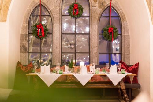a table with wine glasses in front of a window at Hotel Schloss Mittersill in Mittersill