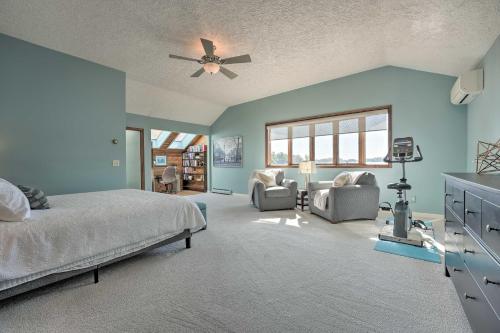 um quarto com paredes azuis e uma cama e cadeiras em Spacious Delton Home with Fire Pit and Lake Views em Delton