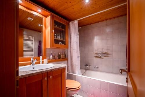 a bathroom with a sink and a toilet and a tub at Sénator 129 in Verbier