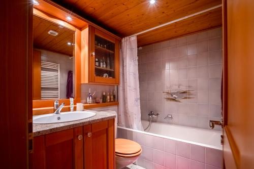 a bathroom with a sink and a toilet and a tub at Senator 129 in Verbier
