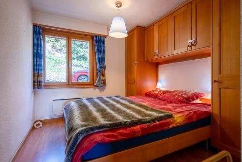 a bedroom with a bed with a red blanket at Senator 129 in Verbier