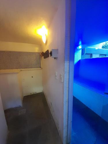 an empty room with a blue light on the wall at Casa Solar in Rio de Janeiro