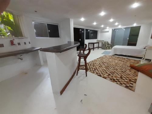 a kitchen and living room with a counter and a chair at Casa Solar in Rio de Janeiro