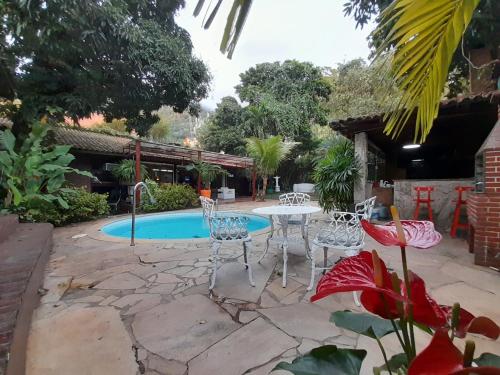a patio with a table and chairs next to a pool at Casa Solar in Rio de Janeiro