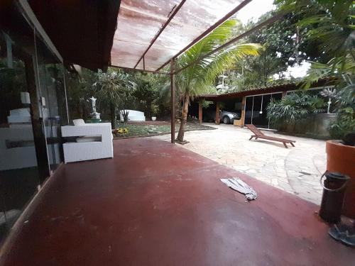 a patio of a house with a bench and palm trees at Casa Solar in Rio de Janeiro