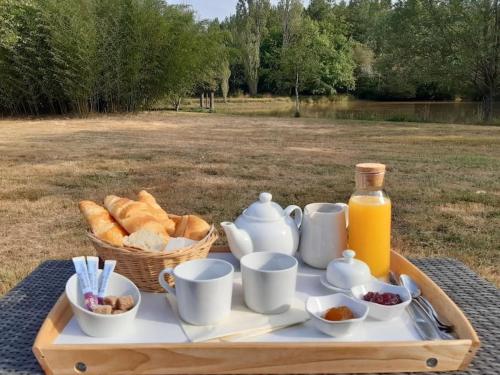 a tray of food with bread and a basket of juice at Maison au cœur des étangs de Sologne avec SPA , Domaine de Sainte-Marie in Ardon