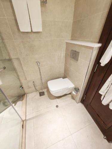 a small bathroom with a toilet and a shower at Best Western Premier Hotel Gulberg Lahore in Lahore