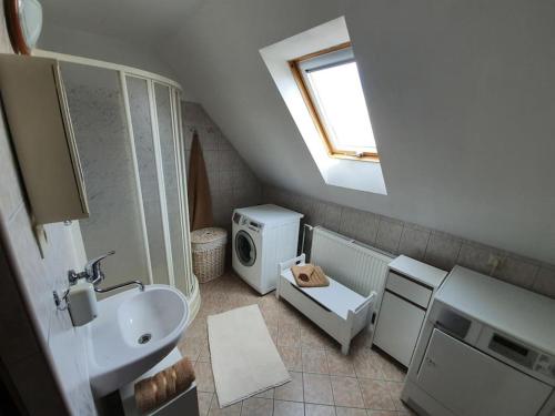 a bathroom with a sink and a washing machine at Chata Damal pri Liptovskej Mare in Žiar