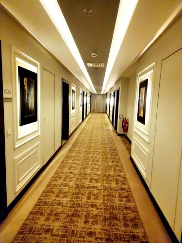 a long hallway with a rug on the floor at Best Western Premier Hotel Gulberg Lahore in Lahore