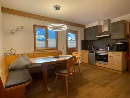 uma cozinha com uma mesa de madeira e uma sala de jantar em Ferienwohnung Gaschurn Ganahl em Gaschurn