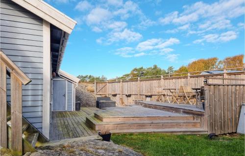 a wooden deck next to a house with a table at 3 Bedroom Stunning Home In Kyrkesund in Kyrkesund