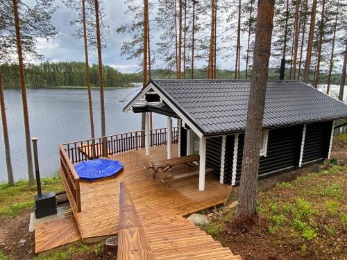 une petite cabine sur une terrasse à côté d'un lac dans l'établissement Villa Norppa, à Punkaharju