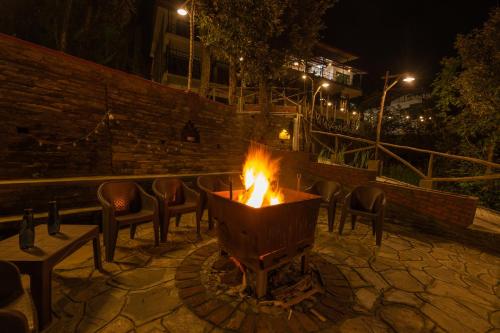 a fire pit with chairs around it at night at THE CEDAR CASTLE in Mukteswar