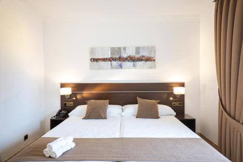 a bedroom with a large white bed with two pillows at Mainake Costa del Sol in Torre del Mar