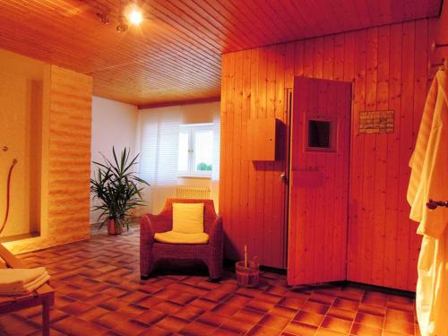 a large room with a chair and a door at Hotel Rappensberg garni in Bad Birnbach