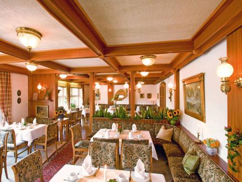 ein Restaurant mit Tischen und Stühlen in einem Zimmer in der Unterkunft Hotel Rappensberg garni in Bad Birnbach