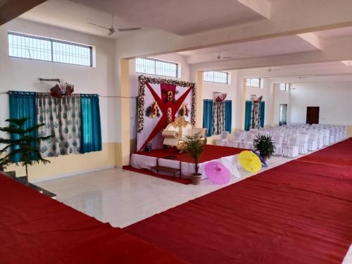 a banquet hall with a red and white dance floor at Vijayam Resort in Nāthdwāra