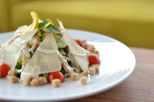 a white plate with a salad on a table at Ciflik Winery in Bitola