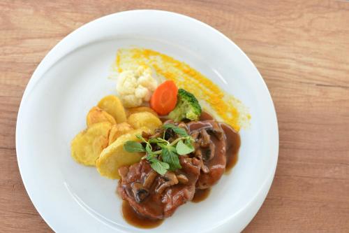 a plate of food with meat and vegetables and potatoes at Ciflik Winery in Bitola