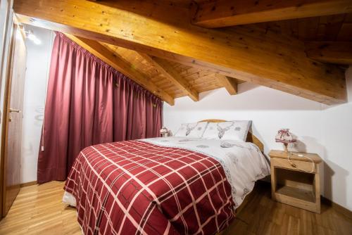 sypialnia z łóżkiem z czerwonym kocem w obiekcie appartamento val di sole w mieście Dimaro