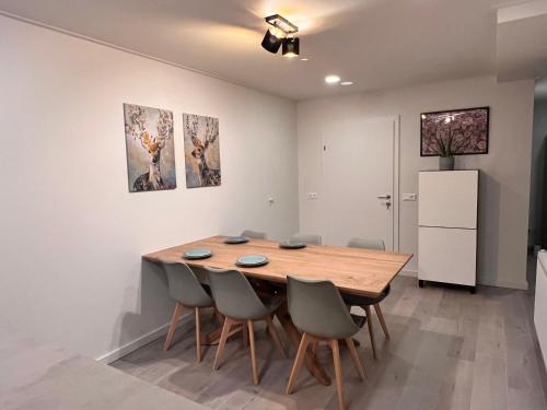 a dining room with a wooden table and chairs at Haus Tilia Karinthië Appartementen in Nötsch