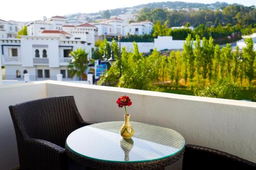 a vase with a flower on a table on a balcony at Hotel Andalucia Tangier in Tangier