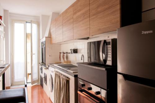 una cocina con electrodomésticos de acero inoxidable y armarios de madera en Amore Se Luxury Apartment en Corato