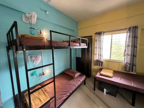a room with two bunk beds and a window at Backpackershostel in Pune